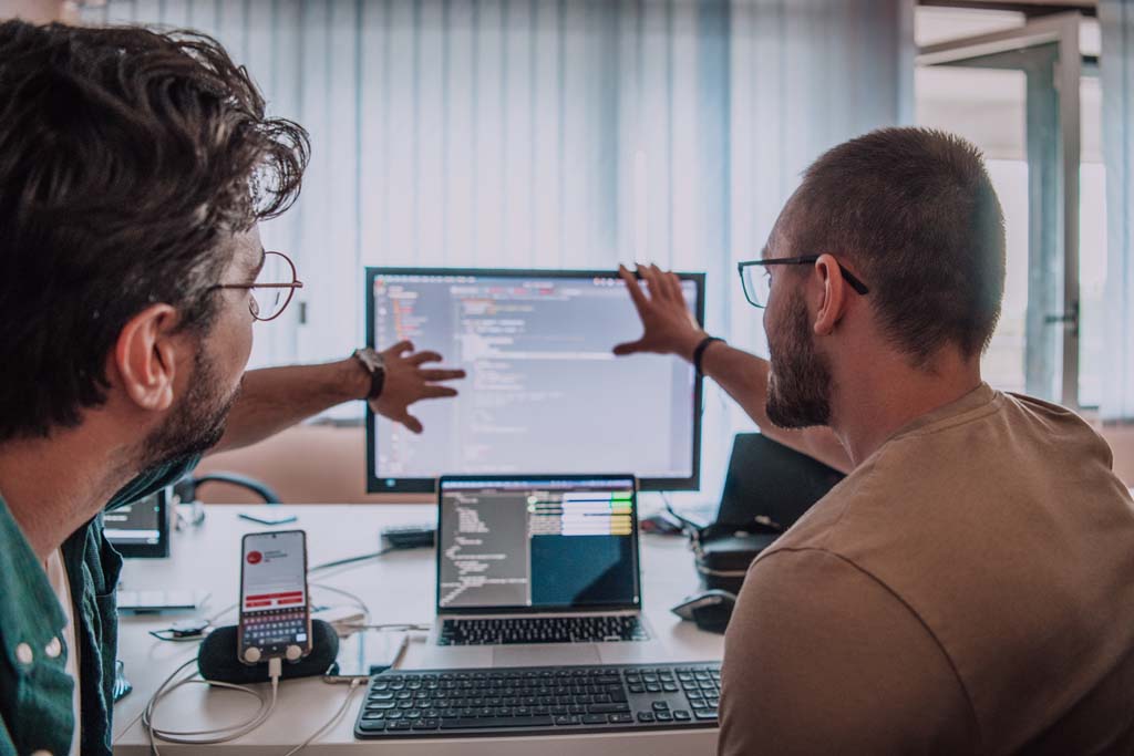 Programmers engrossed in deep collaboration, diligently working together to solve complex problems and develop innovative mobile applications with seamless functionality